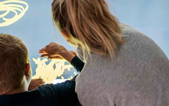 En boende får stöd att utforska en Clevertouch-skärm med hjälp av sin synrest.