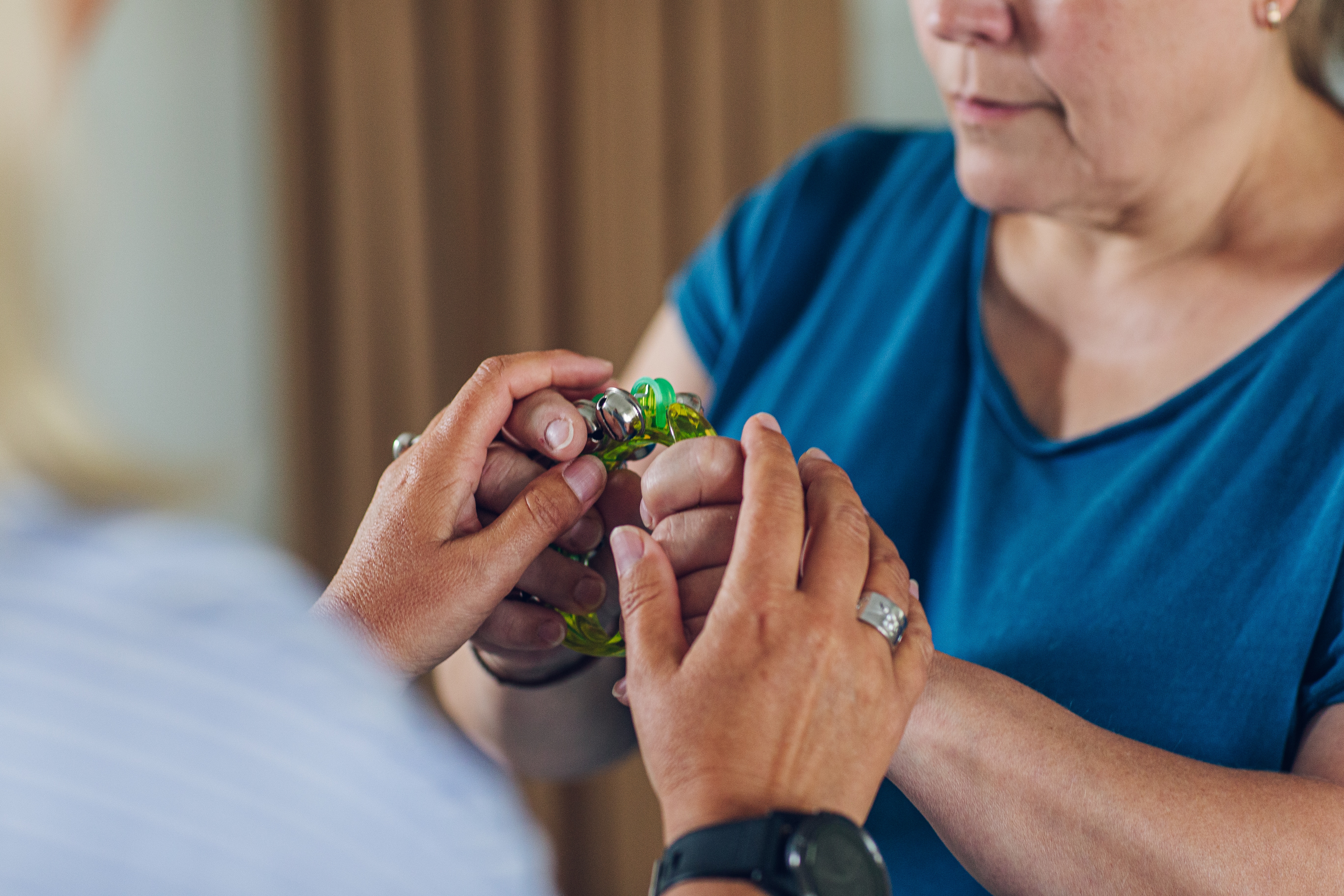 Två vuxna personer håller gemensamt i ett taktilt verktyg