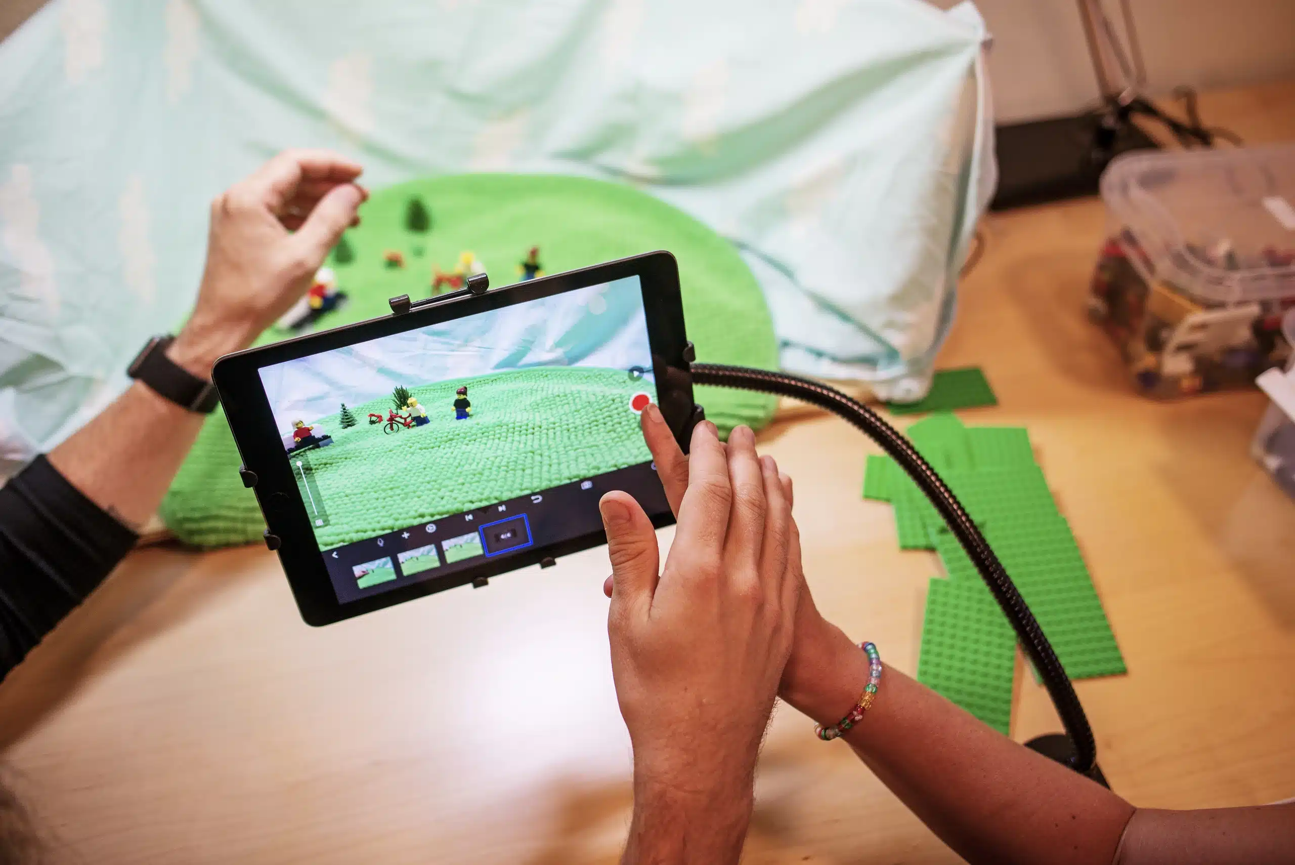 Två personer filmar en stop motion-animation med Lego-figurer på en surfplatta.